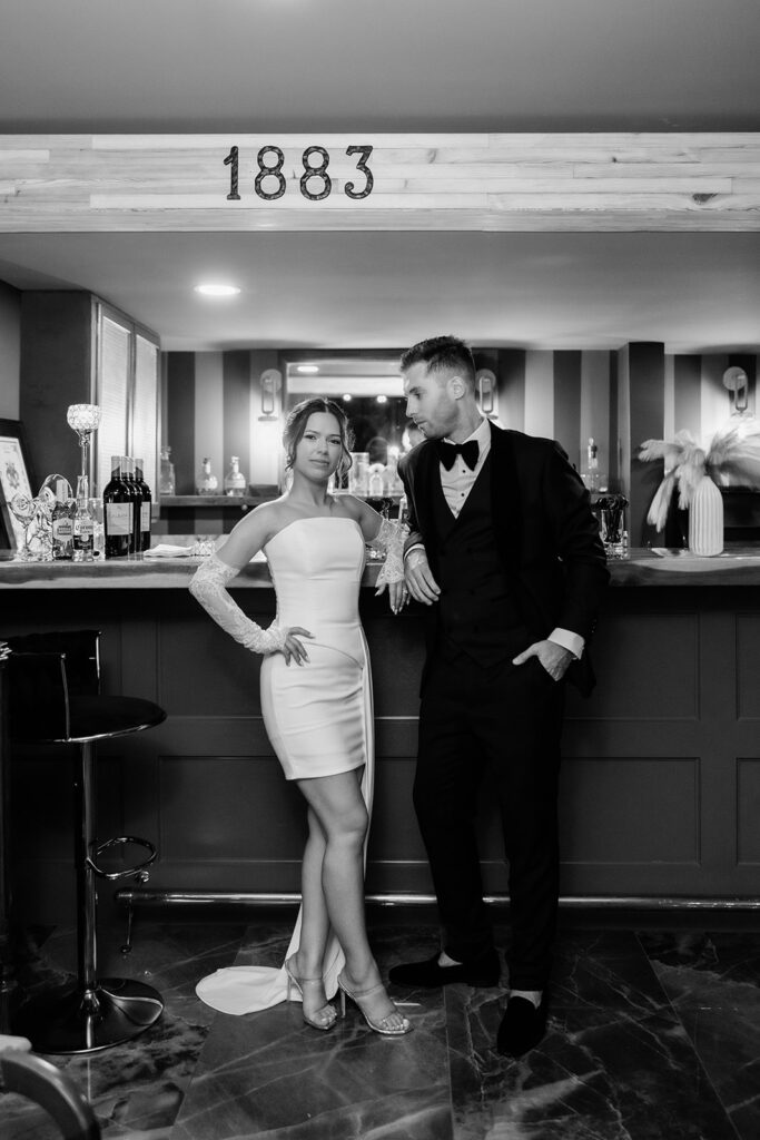Black and white portrait of a couple in the speakeasy on their wedding day Victoria 1883 venue by Florida wedding photographer Angelika Krug Photo & Film.